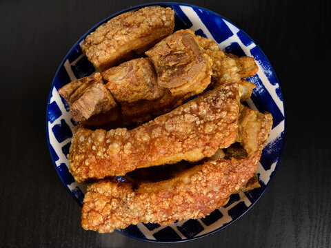 Chicharrones on a Plate Over a Dark Surface
