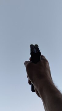 Person shooting a signal pistol into the sky, first person view