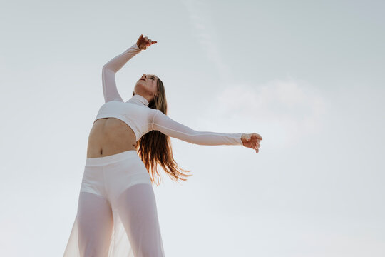 A confident girl performs a graceful dance outdoors