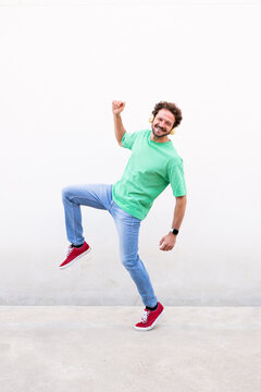 Happy man with headphone enjoys music on white background