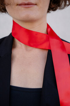 Woman models a red ribbon around her neck with black clothing