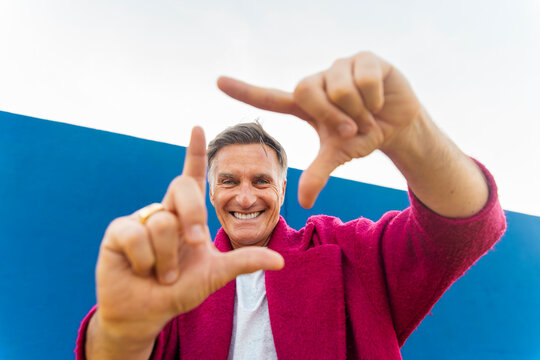 Male director makes a finger frame gesture outdoors in the city