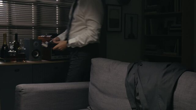 Middle aged Caucasian businessman sitting on couch, unbuttoning collar and loosening tie after exhausting workday. Perfect for corporate burnout, mental health, or stress management videos