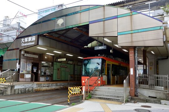 Red streetcar stopped at covered tram stop platform in Tokyo, Japan