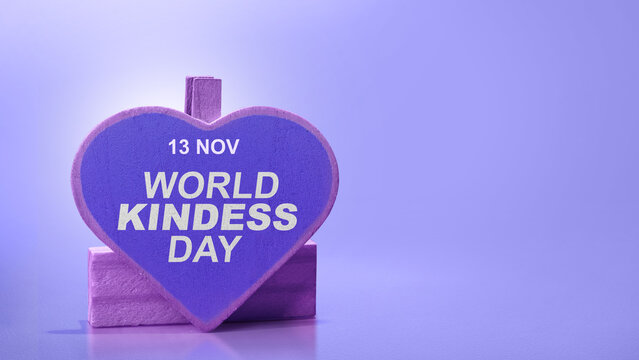Purple heart-shaped sign on a stand celebrating World Kindness Day on November 13, set against a solid purple background. Concept of World Kindness Day