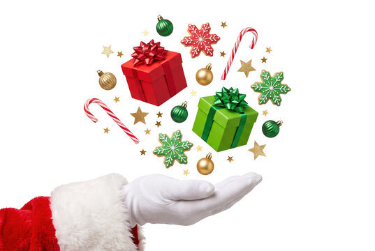 Santa hand holding floating christmas decorations with canes star cookies on transparent background