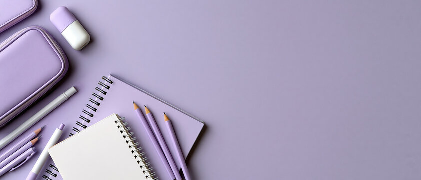 Creative workspace inspiration for students and designers spiral notebooks, pencils, ruler, eraser, and pencil case arranged on a soft purple background with generous copy space.