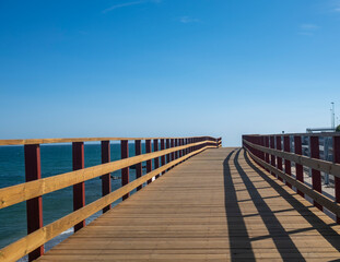 Obraz premium Wooden boardwalk leading towards the Mediterranean Sea in Fuengirola, Spain