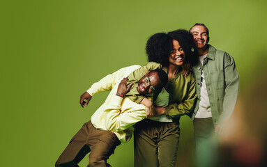 Friends posing together in playful studio portrait with happy young people and urban style