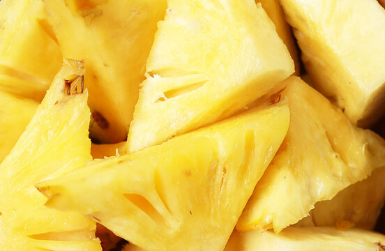 Fresh, ripe triangular pineapple pieces on white background