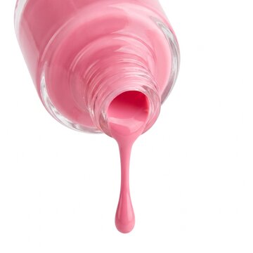 Pink nail polish dripping from an inverted glass bottle isolated on a white studio background