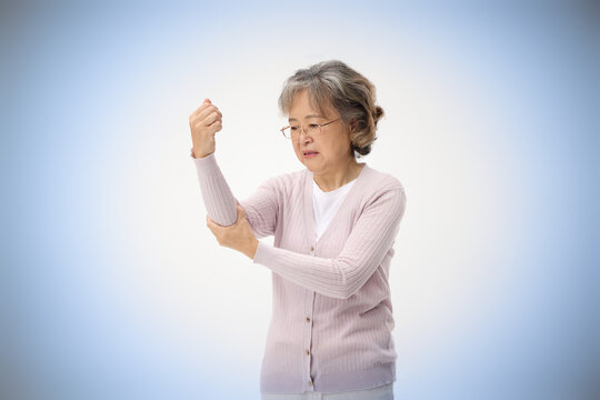 Senior woman massaging elbow in pain