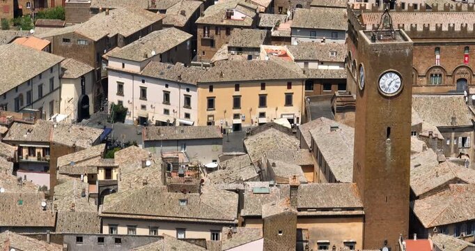 Aerial view of Torre del Moro, a medieval clock tower in the town centre of Orvieto, province of Terni, Umbria, Italy. The tower rises above dense terracotta roofs in the historic old town.