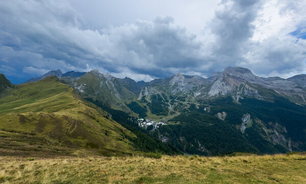 Mountain landscape scenic view, in high-altitude valley with forested slopes and rocky peaks, with mountains, valley, forested slopes, rocky peaks, with green, gray accents.