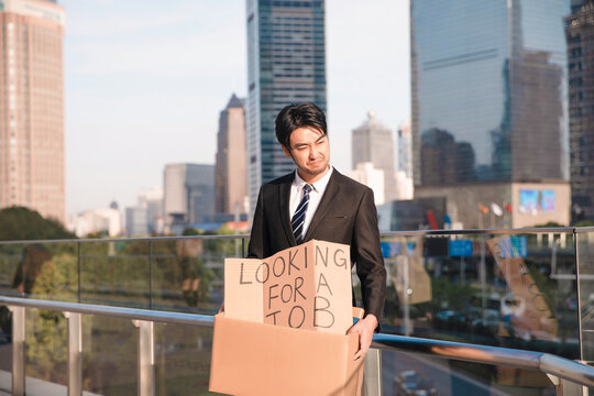 Businessman Looking for Job on Rooftop Sign