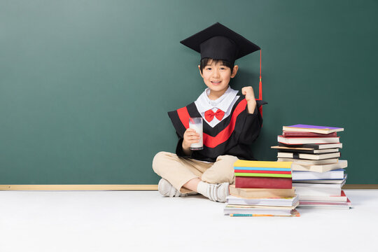 Happy Young Boy Celebrates Graduation with Milk and Books