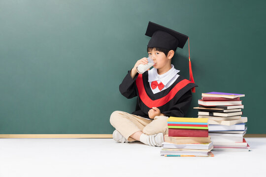 Child in Graduation Cap Drinking Milk with Book Stacks