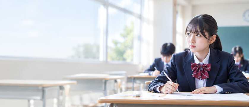 教室で模試を受けながら問題を考える女子高校生とコピースペース