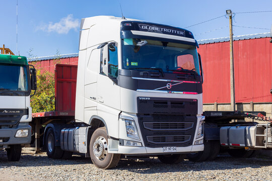 A white Volvo FH Globetrotter semi‑truck stands on a gravel lot in Angol, Chile
