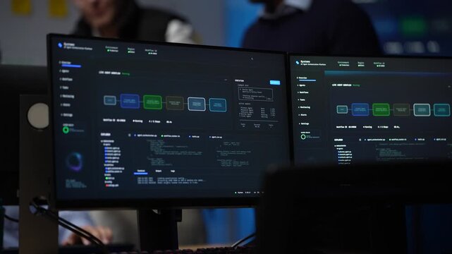 Twin monitors filling the frame run the agent orchestration canvas while the team works on behind the glass of the screens inside a dimly lit machine learning startup office.