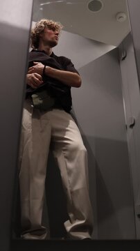 Vertical screen shoplifter steals clothes from a fitting room secretly hiding garments and trying to leave the clothing store unnoticed after committing a retail theft inside