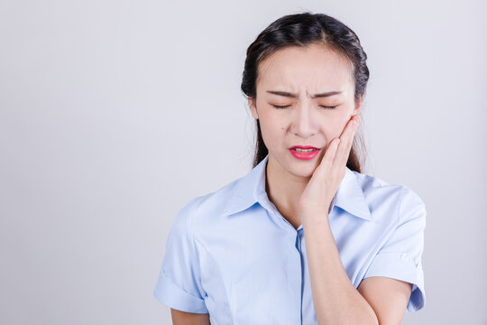 Woman in pain holding cheek