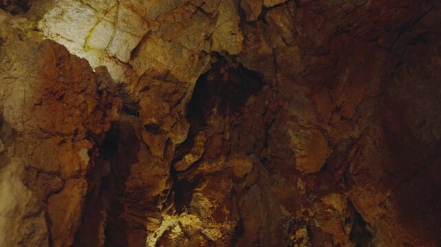 Explore the dark and intriguing world of a cave with this image showcasing natural rocky textures and earthy colors, perfect for adding a sense of adventure to any project.