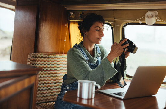 Capturing memories on a road trip: photographer inside a van with camera and laptop
