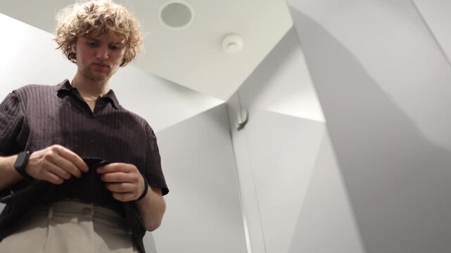 Man feels the fabric of a T shirt with his hands while shopping carefully checking its texture softness quality and comfort before deciding if the garment is worth buying