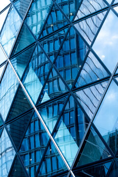 Blue glass architecture with intersecting steel beams and reflective panels where structural geometry creates a dramatic abstract pattern inside the frame