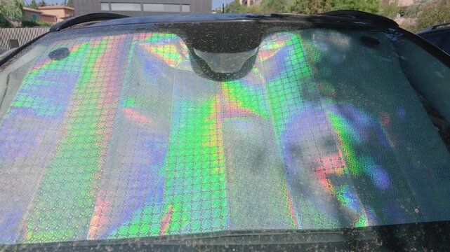 Close-up of a holographic sun shade reflecting light in a parked car windshield, Cote d'Azur, France