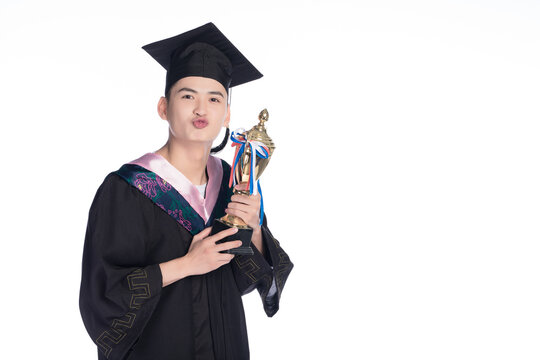 Young Asian male graduate holding trophy puckering lips