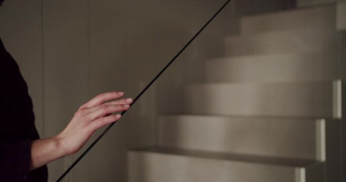 A mysterious photo capturing an elegant woman in a deep black dress as she gently places her hand on a glass partition. Elegant Woman in Black Gown Touching a Glass Wall