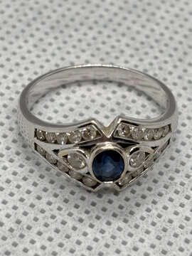Silver-toned ring with blue center stone and clear crystal accents