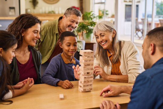 Happy multiethnic generation family playing with block removal game