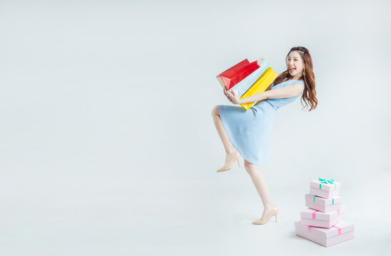 Happy Woman Shopping with Colorful Bags and Gift Boxes
