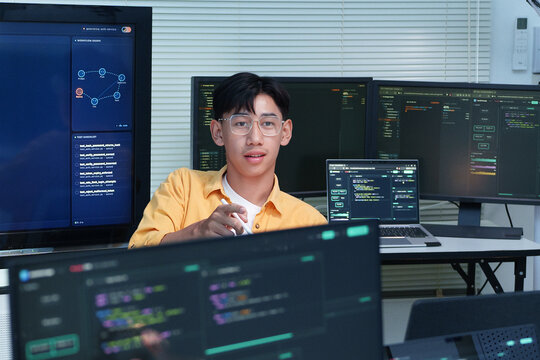 Programmer Working with Code on Multiple Digital Screens