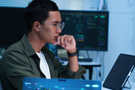 Thoughtful Programmer Working on Digital Code