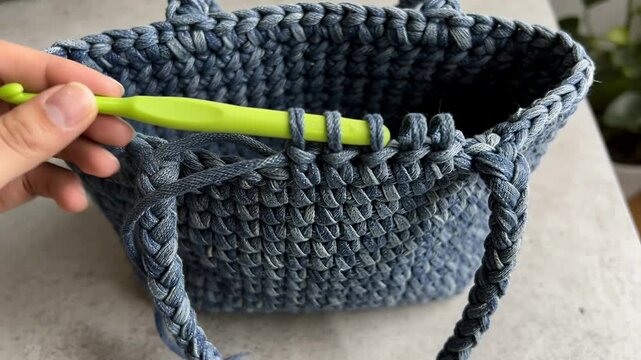 Hooking loops, hand pulling yarn through basket rim at home, finishing rim stitch with green hook