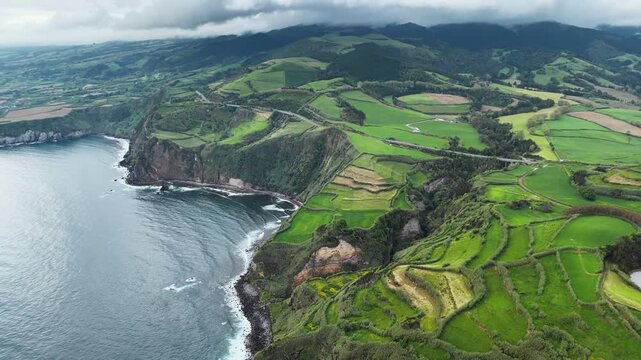 Patchwork rural fields on volcanic coastal terrain above Atlantic Ocean, Azores. Aerial view