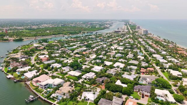 Aerial neighborhood between Jupiter Inlet and Atlantic coastline, drone panoramic establishing orbit for real estate, West Palm Beach Florida USA