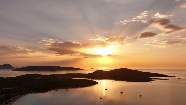 Aerial view of sea bay and bright sunrise over Capo Coda Cavallo, Sardinia