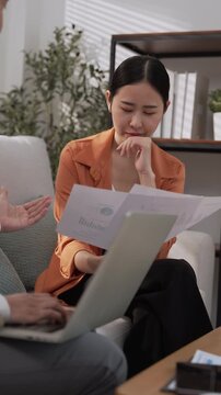 Financial advisor wealth planning consultation with Asian client using laptop for investment guidance, household budget review, personal finance discussion, and confident financial decisions at home