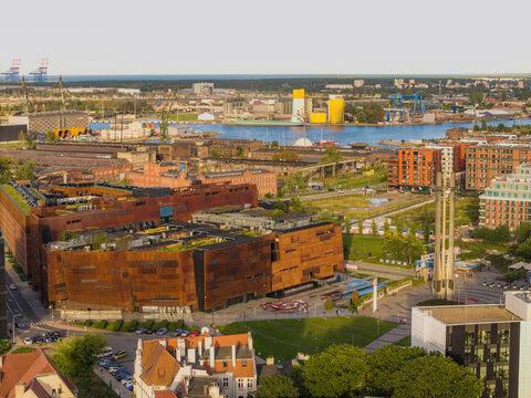 Aerial view of the European Solidarity Centre with its rusted corten steel facade and green roof, located near the historic shipyard area in Gdansk, Pomeranian Voivodeship, Poland.