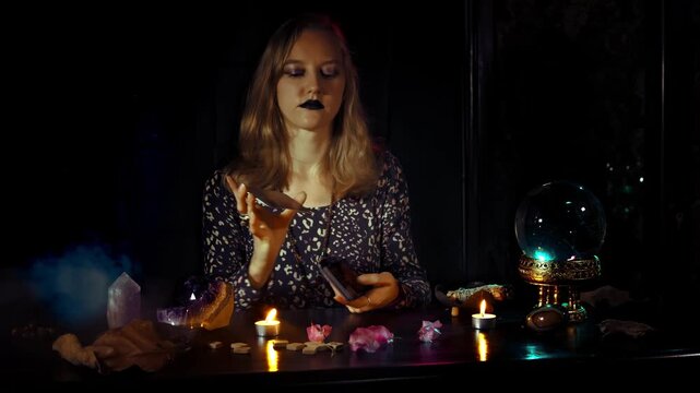 Enigmatic Witch Performs Tarot Reading Under Candlelight, Discovering Secrets and Mysteries of the Unknown in a Halloween-Inspired Setting