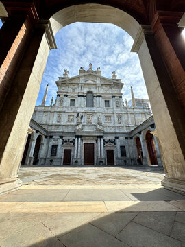 Milan, Italy - 03 30 2025: facade of the Santuario di Santa Maria dei Miracoli presso San Celso in Milan, framed by the elegant arches of the internal colonnade beneath a clear blue sky