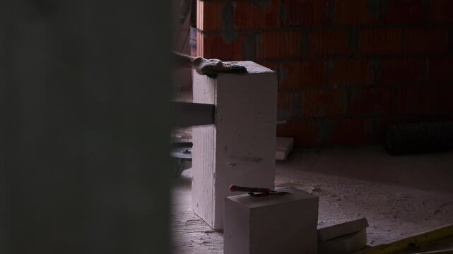 Worker cutting masonry block with hand saw during construction