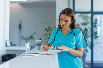 Healthcare worker reviewing patient records at a clinic front desk