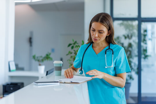 Healthcare worker reviewing patient records at a clinic front desk