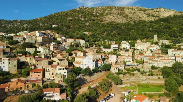 Scenic aerial drone view of Lumio perched village in Balagne Corsica France. Panoramic view over Calvi bay old stone houses cinematic sunset 4K